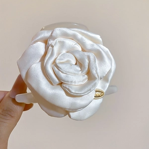 Dettaglio di un fermaglio per capelli a rosa in raso bianco crema con base in acrilico