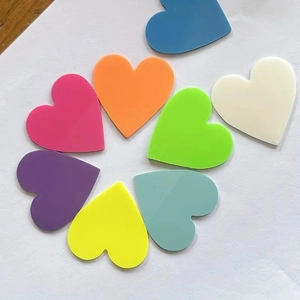 Flat lay of colorful heart-shaped sticky notes arranged in a circle on white background