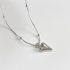 Polished 925 sterling silver heart pendant necklace with beaded snake chain on white background