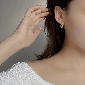 Close-up of minimalist golden S925 sterling silver double-layer hoop earrings on a model
