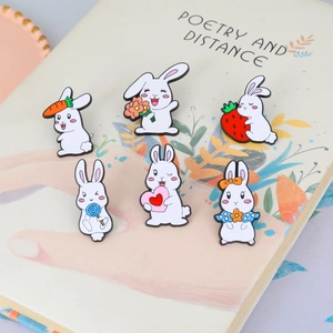 Set of 6 colorful cartoon rabbit metal badges with carrots and flowers on a book