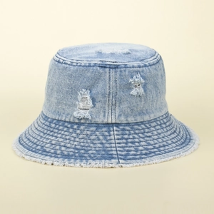 Close-up of light blue denim sun hat with distressed holes and frayed edge details