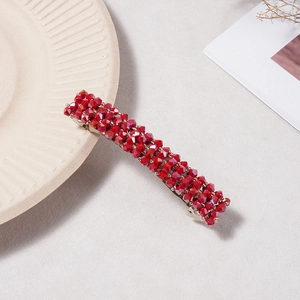 Vue détaillée d'une barrette en cristal rouge avec base en métal argenté sur fond neutre