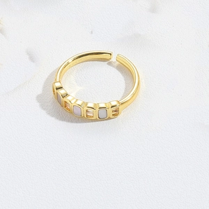 Close-up of gold adjustable ring with rectangular pink and white zircon stones inlay