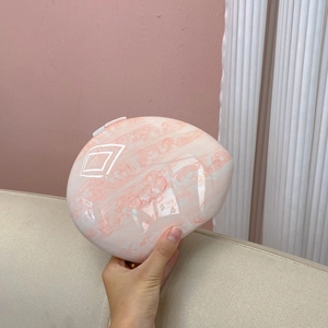 Detail of pink marble pattern evening clutch bag with high-gloss finish and oval shape