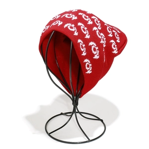 Detail of red knit beanie with white jacquard pattern and soft ribbed cuff