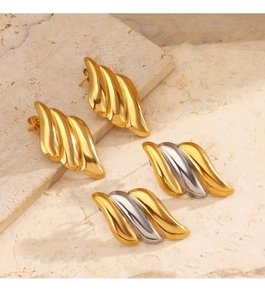 Détail des boucles d'oreilles asymétriques à texture ondulée en acier doré et argent
