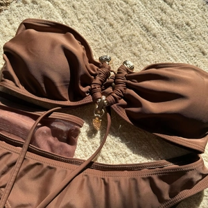 Détail du haut de bikini marron chocolat avec anneau doré en métal et tissu froncé