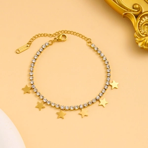 Macro detail of gold stainless steel star bracelet with zirconia crystals and extension chain