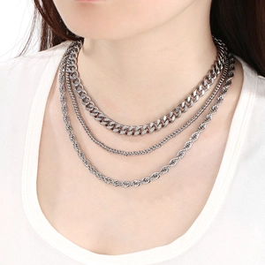 Close-up of three-layered silver stainless steel cuban, ball, and rope chains on neck