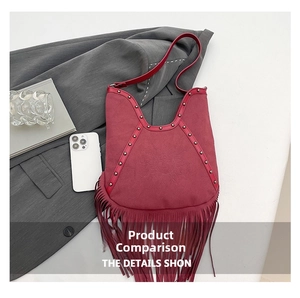 Macro detail of wine red suede tassel bag with sun relief and metal studs decoration