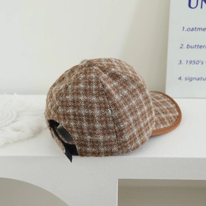 Vue détaillée de la casquette en laine à carreaux marron avec bordure en cuir