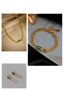 Detail view of gold chain jewelry set with green rectangular gemstones and K18 hallmark