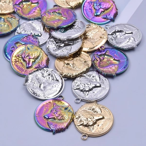 Macro detail of round wolf head embossed charms in gold, silver, and rainbow steel