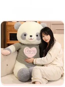 Detail of a large panda plush toy wearing a grey knitted sweater with a pink love heart