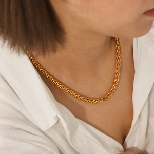 Close-up of 18K gold plated stainless steel wheat chain necklace worn by a model