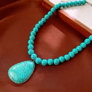 Vintage turquoise beaded necklace featuring a large teardrop stone pendant and metal edges