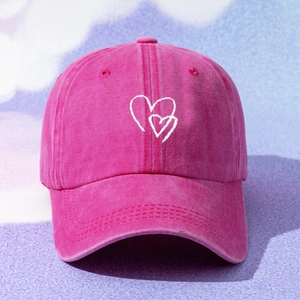Detail of rose pink washed cotton baseball cap with white heart embroidery design