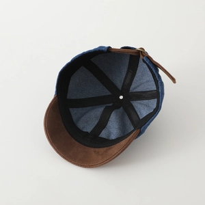 Dettagli interni del cappellino bimbo in denim blu con visiera in pelle scamosciata