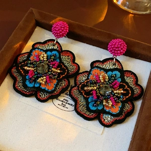 Macro shot of colorful seed bead embroidered flower earrings with tiered petal details