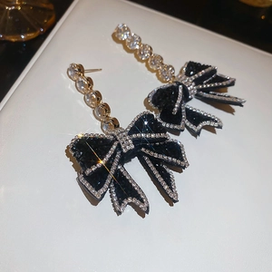 Detail of elegant black velvet bow earrings with micro-set crystals and zircon drops