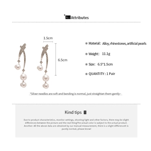 Detail view of rhinestone crossover earrings with artificial pearls measuring 6.5cm by 1.5cm