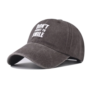 Detailed macro view of embroidered 'DON'T FORGET TO SMILE' on washed cotton baseball cap