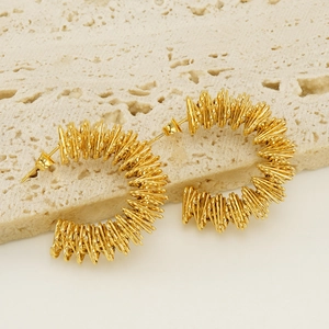 Textured 18K gold plated stainless steel spiral hoop earrings on natural stone background