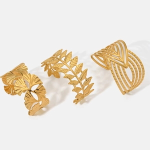 Three-piece gold stainless steel open cuff set featuring ginkgo and laurel leaf designs