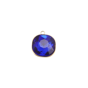 Vue macro d'un pendentif carré en pierre de naissance bleue avec serti en acier doré