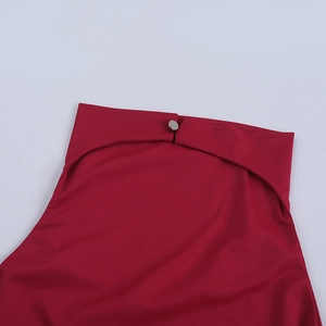 Close-up of a red high-neck halter top featuring a smooth knit fabric and silver button detail