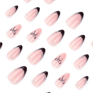 Almond-shaped press-on nails with pink base, brown French tips, and bow details