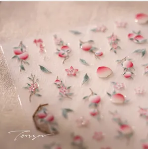 Macro shot of 3D peach and floral nail stickers with frosted textures and petal motifs