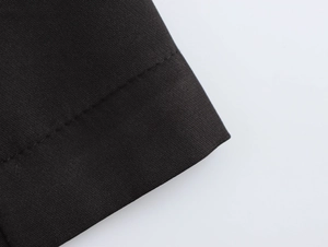 Close-up of black beaded blazer dress sleeve showing premium woven fabric and stitching