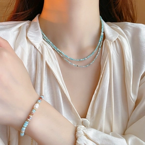 Detail of a gold-plated necklace set with blue and white beads and baroque pearls