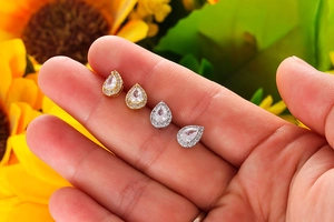 Detailed close-up of teardrop-shaped zircon earrings in gold and silver finish