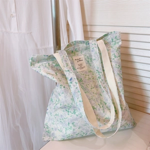 Detailed texture of floral cotton tote bag with vintage label and woven canvas handles