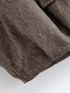 Detail of premium brown and beige herringbone tweed fabric with thick texture