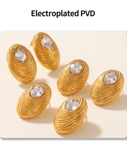 Detail of 18K gold plated oval earrings with bird nest texture and clear crystal stone