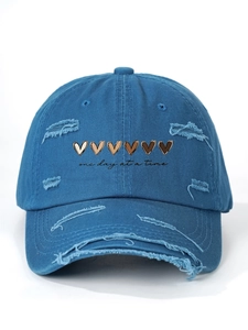 Detailed view of the embroidered hearts and one day at a time text on distressed denim cap