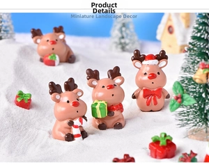 Detailed view of Christmas elk figurines with festive accessories in a snowy landscape