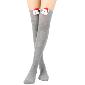 Close-up of grey knit over-the-knee socks featuring 3D plush Santa Claus decorations
