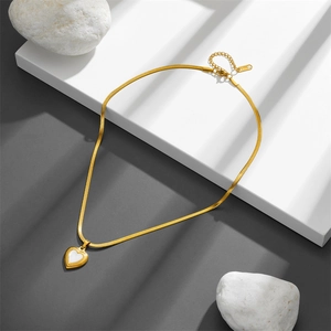 Collier élégant chaîne serpent dorée avec pendentif cœur en nacre sur présentoir