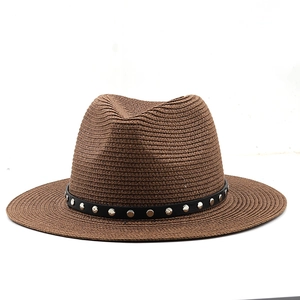 Close-up of brown straw fedora hat featuring a black leather band with silver metal studs