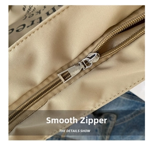 Detail of smooth silver metal zipper and letter printed lining on canvas tote bag