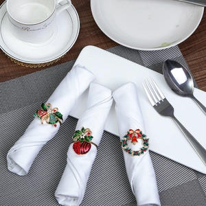 Festive Christmas napkin rings with reindeer and wreath designs on a set dining table