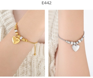 Detail of gold and silver heart bracelets with 'I love you' engraving on snake chains