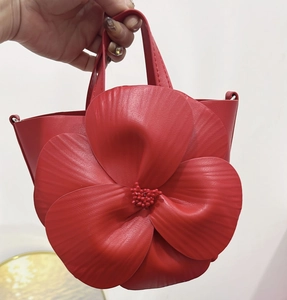 Detail of bright red tote bag featuring large 3D floral petals with fine vein textures