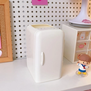 Close-up of a white refrigerator-shaped desk organizer in a cute workspace setting