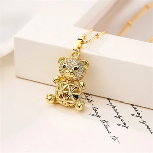 Macro detail of gold bear pendant with hollow geometric body and micro-pave zircons